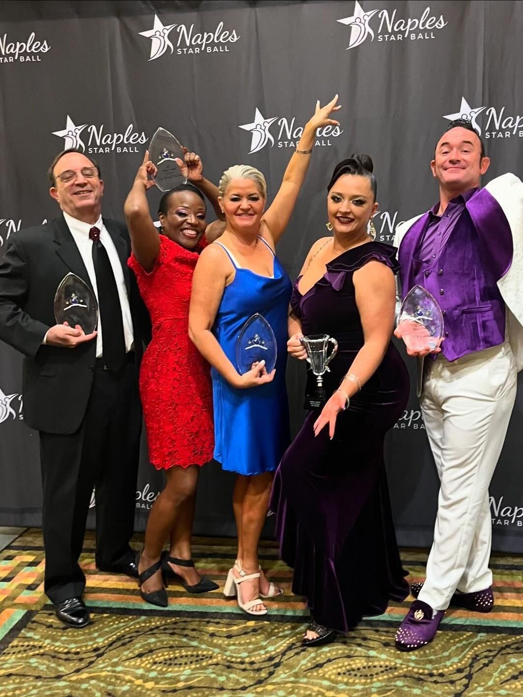 Performers photo ops on backdrop at Naples star ball